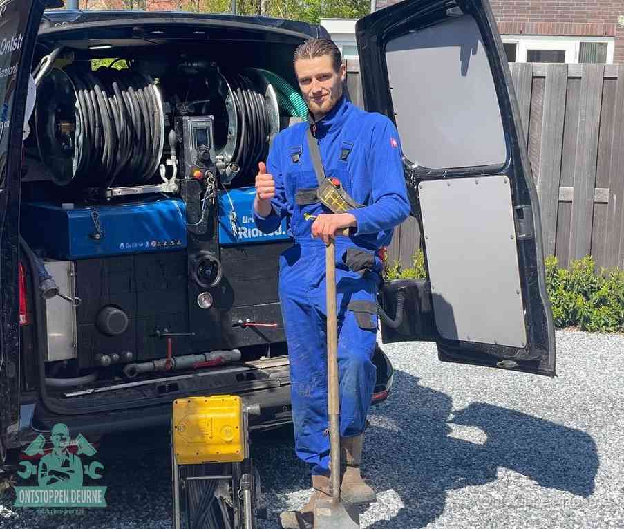 Een monteur bij de werkbus met grote hogedruk-slanghaspels, apparatuur voor hardnekkige afvoerverstoppingen in Deurne