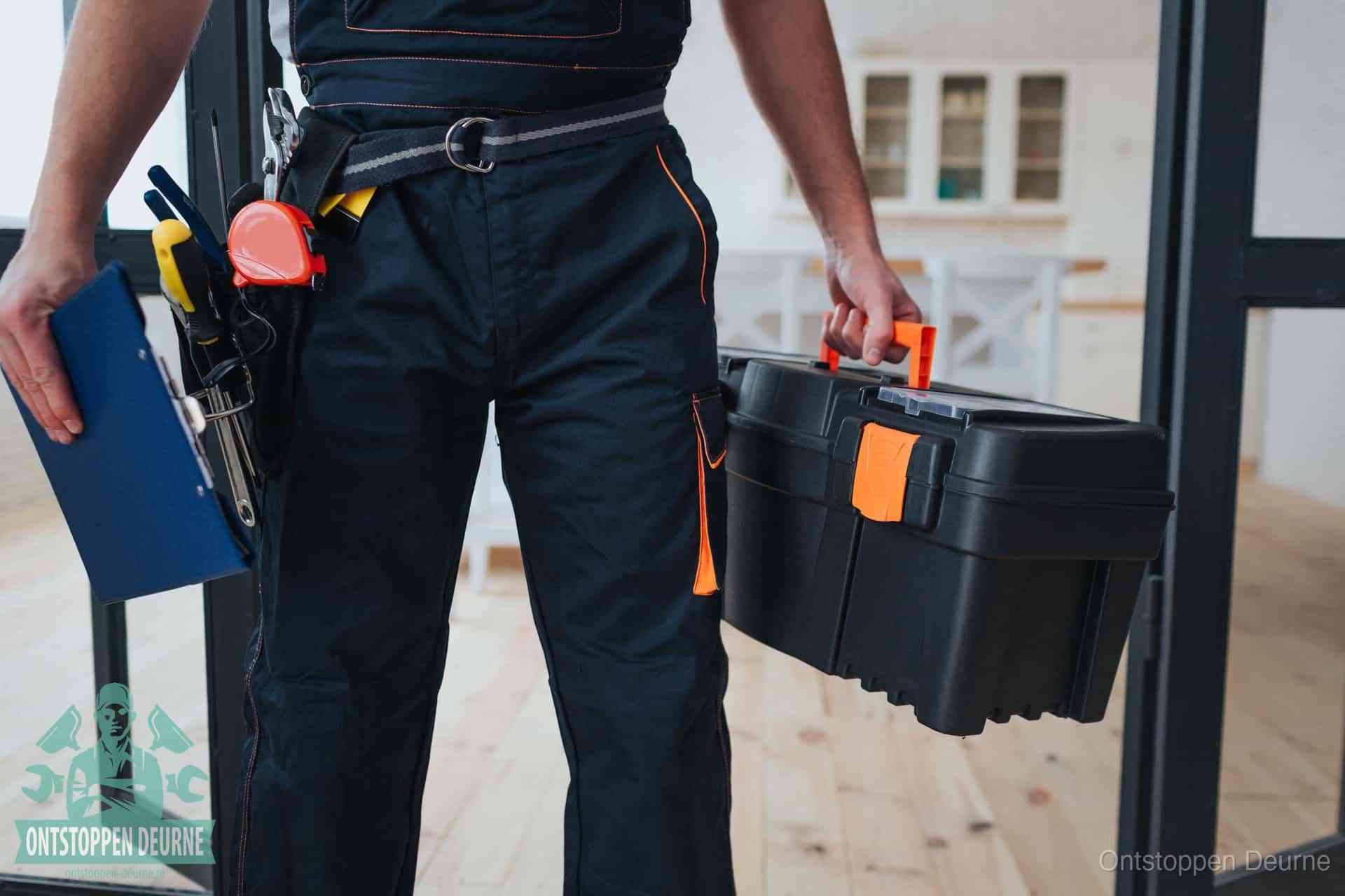 Een monteur met gereedschapsriem en klembord in een keuken, klaar om een transparante prijs voor het gootsteen ontstoppen in Deurne te geven