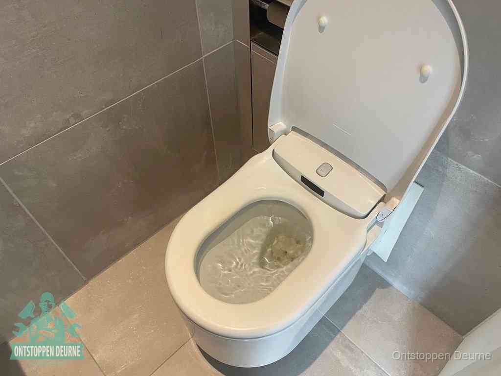 Een toiletpot vol troebel water met drijvend papier en restanten, de meest voorkomende oorzaak van een verstopte wc in Deurne