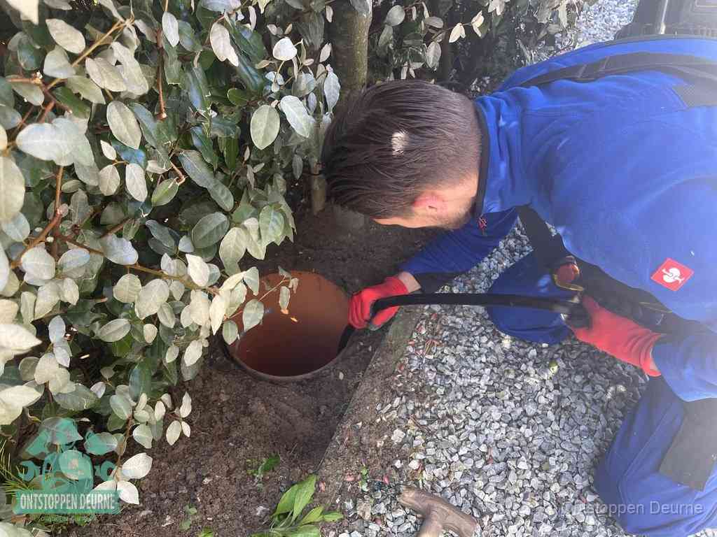 Monteur reinigt een rioolput met een slang, periodieke rioolreiniging in Deurne