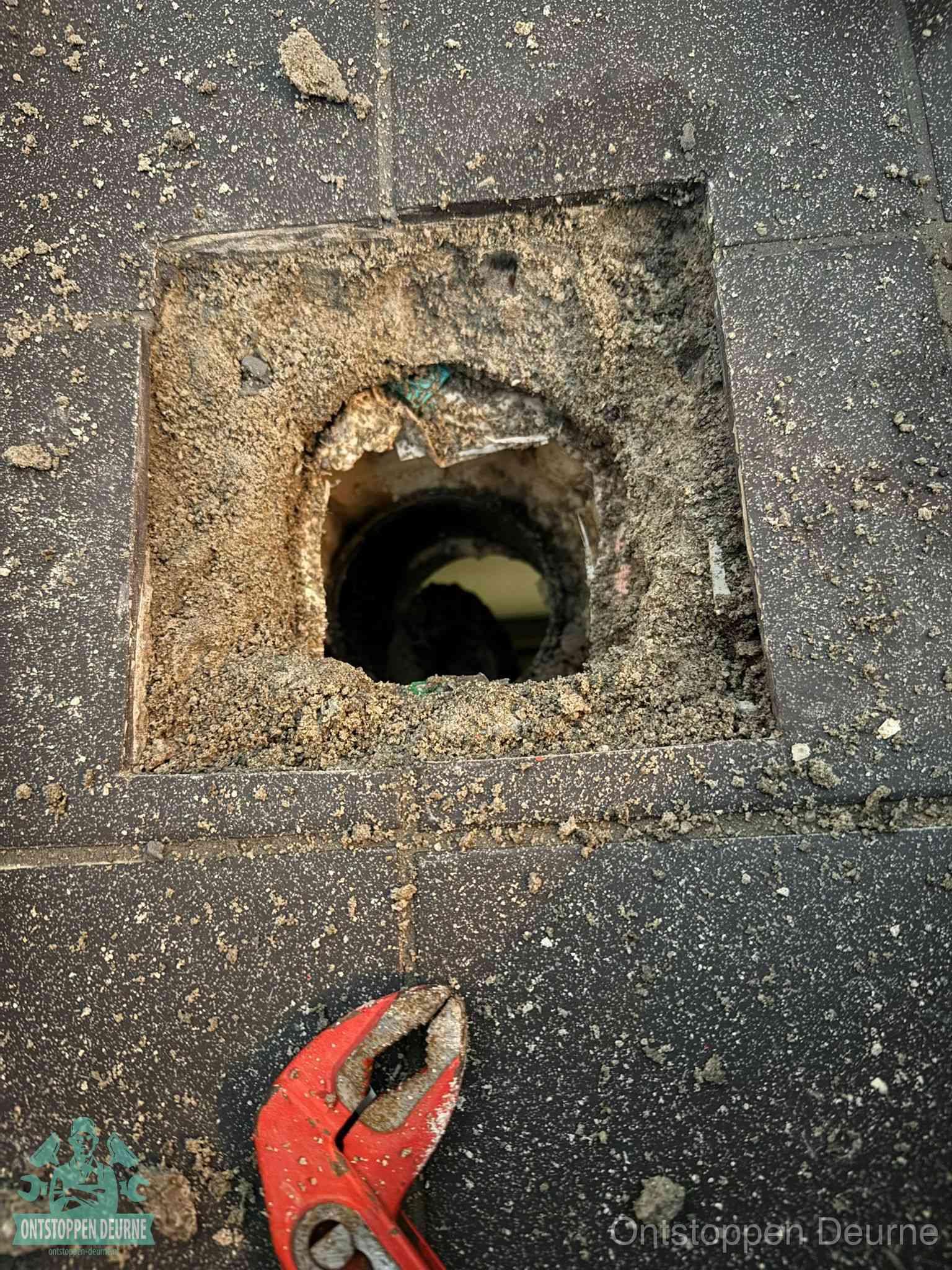Geopend rioolputje op de erfgrens dat laat zien wie eigenaar is van de riolering in Deurne