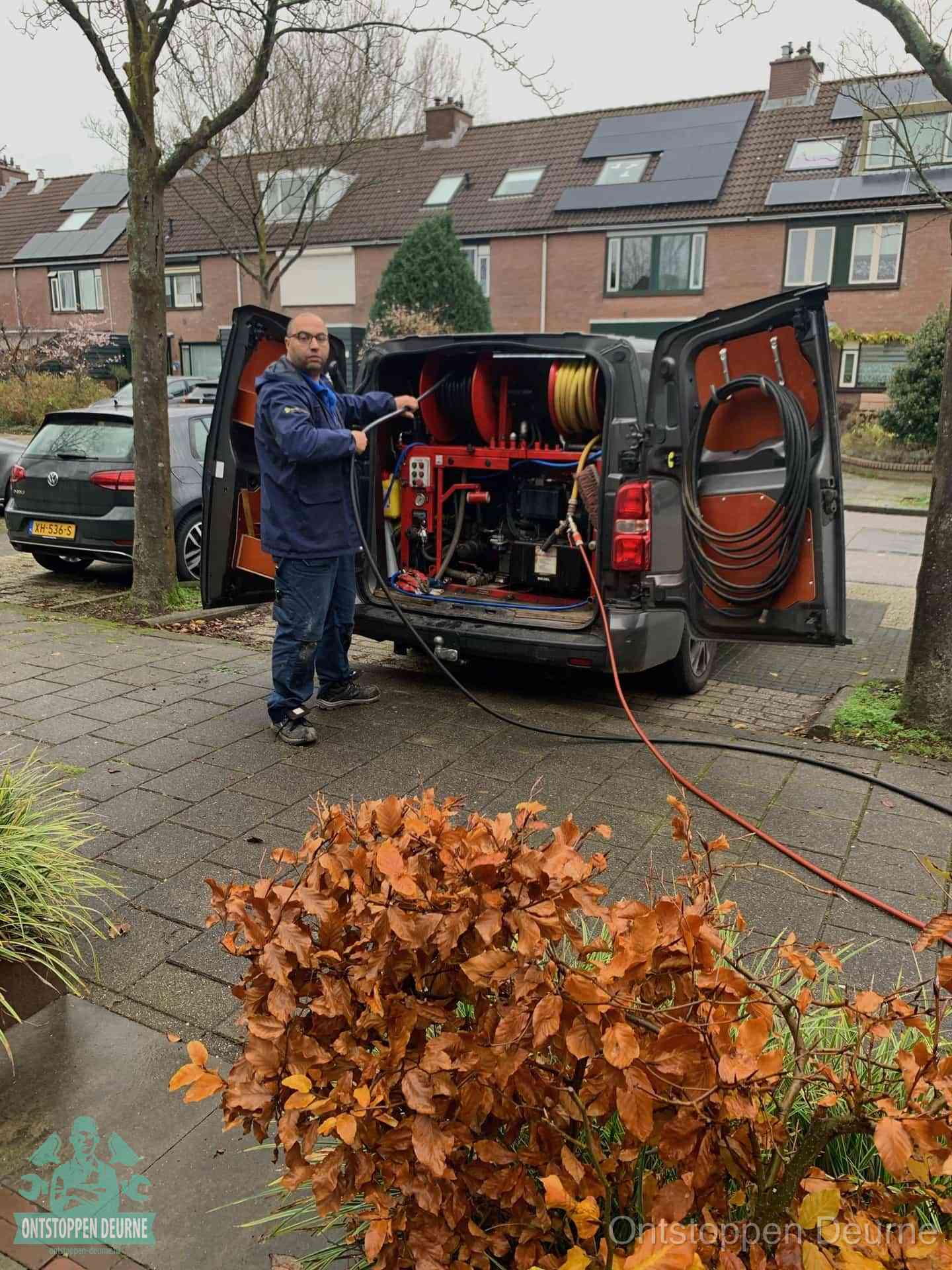 Monteur met rioolreinigingsbus levert rioolservice in de wijk in Deurne