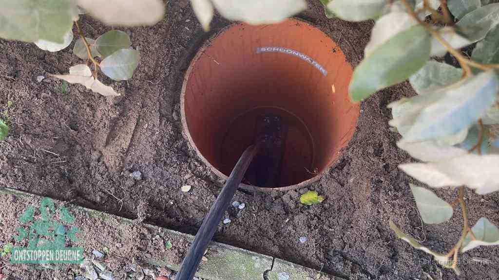 Open inspectieput in de tuin waar een veer rioolvliegjes en stankoverlast aanpakt in Deurne