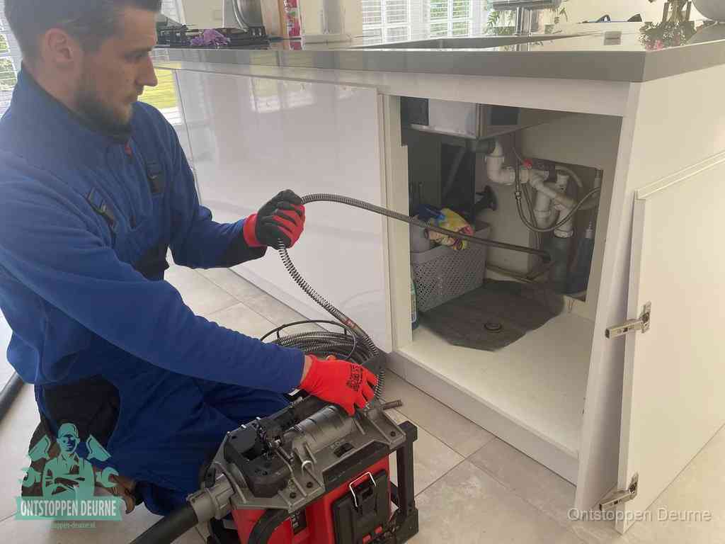 Een monteur reinigt de keukenafvoer grondig met een veermachine om terugkerende gootsteenverstoppingen te voorkomen in Deurne